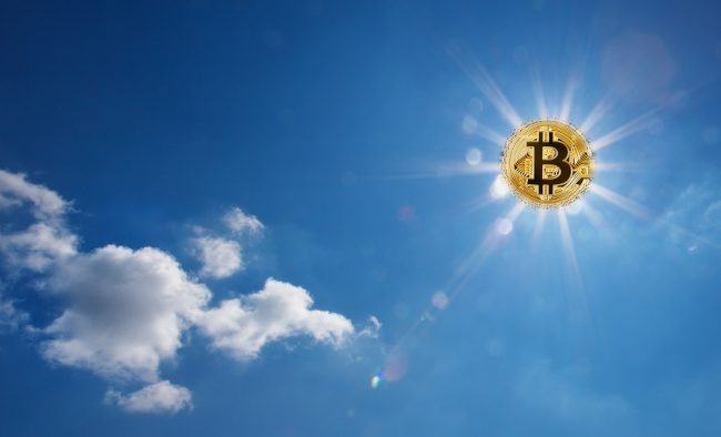 Golden bitcoin glowing in the blue sky instead of the sun. Bitcoin with divergent rays in the sky. The concept of the onset of the bitcoin era.