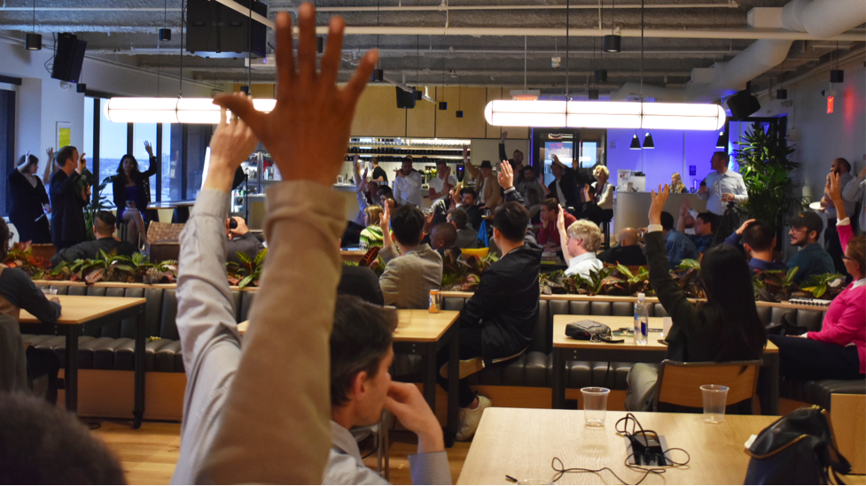 People at a conference raising their hands.