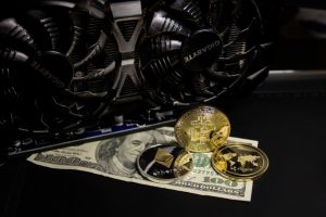 Computer fans with gold bitcoin coins and 100 dollar bill.
