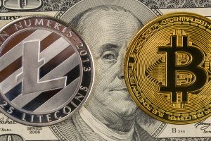 Litecoin symbol on a silver coin and bitcoin symbol on a gold coin.