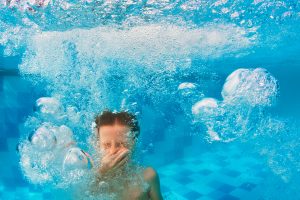 Person holding their nose under water.