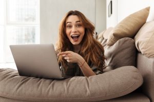 happy woman pointing to her laptop