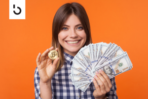 woman holding cash and a bitcoin