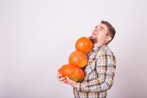 farmer holding pumpkins