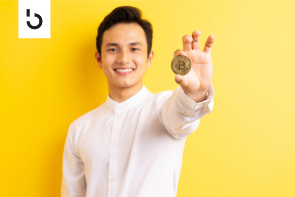 smiling man holding a cryptocurrency coin