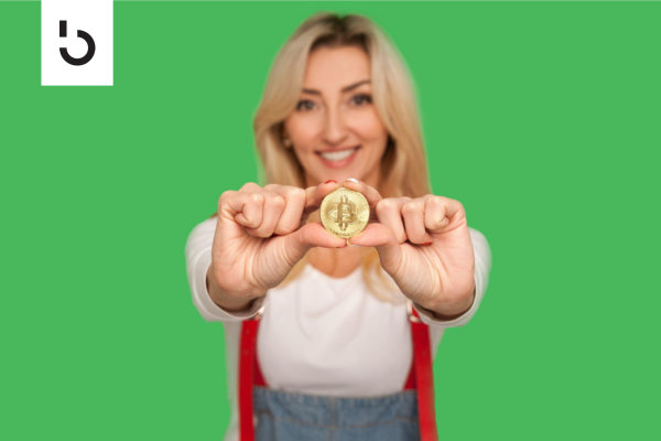 woman holding a coin with bitcoin logo