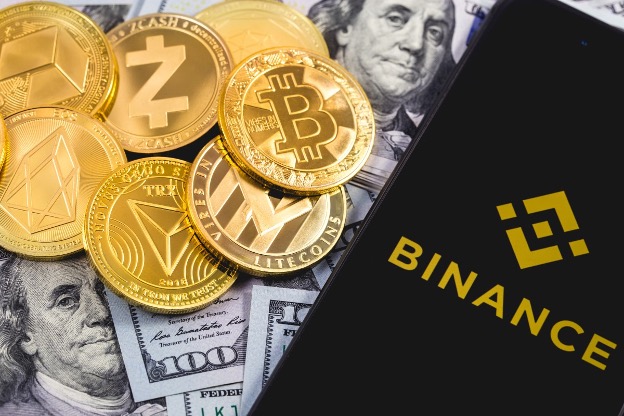binance app on a smart phone and gold coins